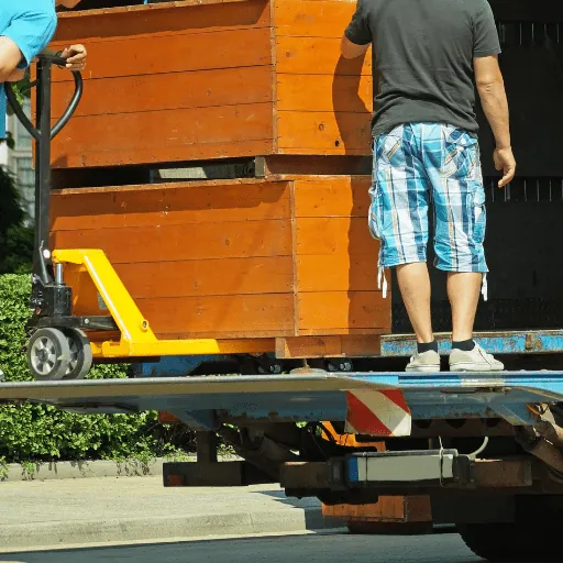 Holzmöbel werden mit einem Hubwagen auf die Ladefläche eines Lkw gebracht